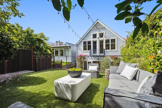 rear view of property with fence, a yard, and outdoor lounge area