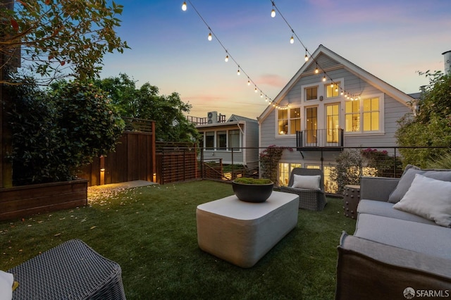 back of house featuring a lawn, fence, and an outdoor hangout area