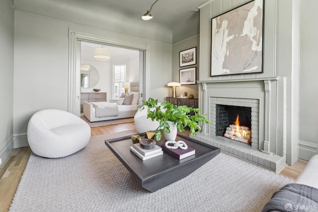 living room featuring light wood-style floors, baseboards, and a fireplace
