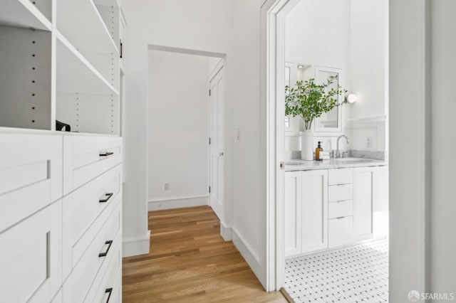 spacious closet featuring a sink and light wood-style flooring