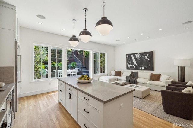 kitchen featuring light wood-style floors, a kitchen island, and open floor plan