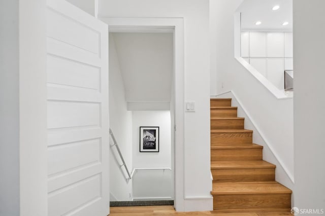 stairs featuring recessed lighting and wood finished floors