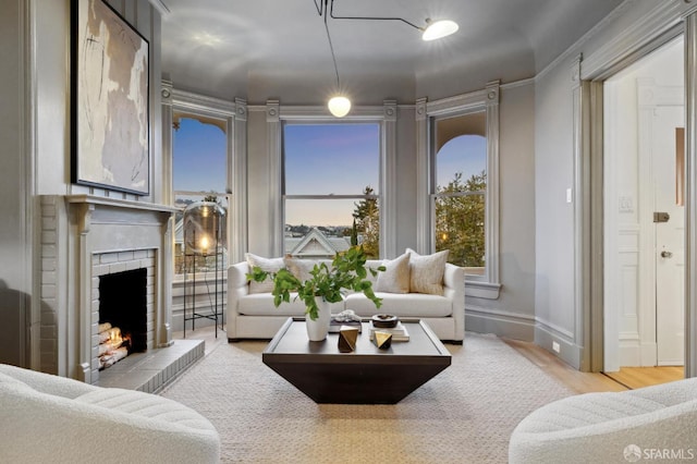 interior space featuring baseboards, a brick fireplace, and wood finished floors