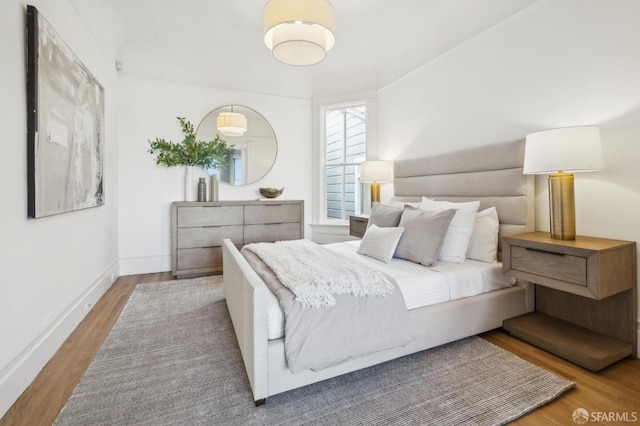 bedroom with baseboards and wood finished floors