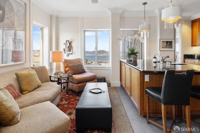 tiled living room with crown molding, sink, and a wealth of natural light