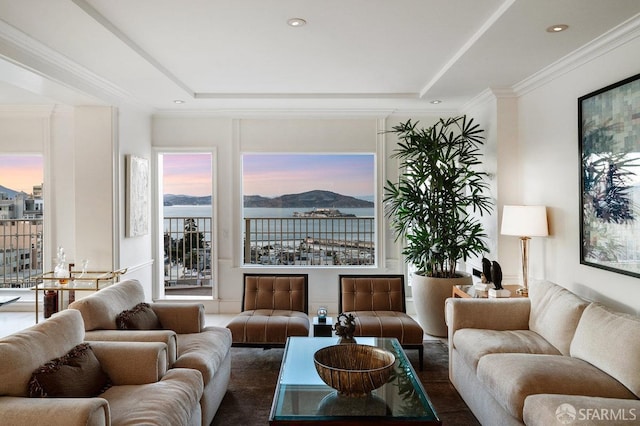 living room featuring a water view, recessed lighting, crown molding, and a raised ceiling