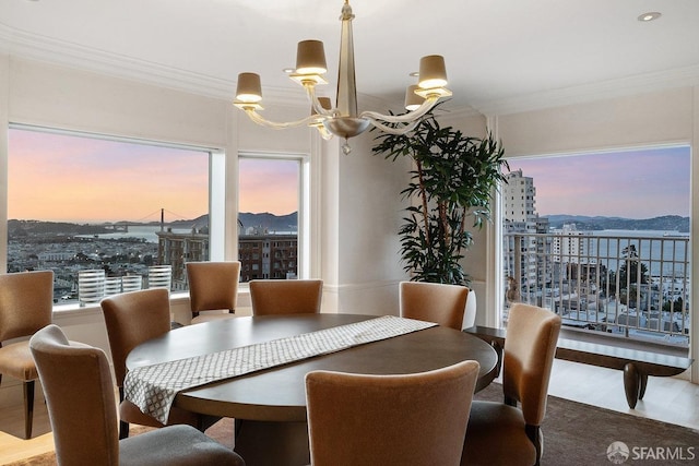 dining space featuring crown molding, an inviting chandelier, and a city view