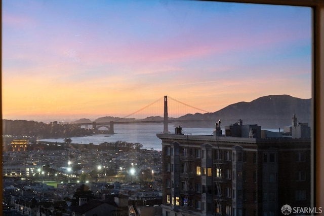 property's view of city with a water and mountain view