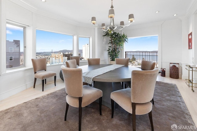 dining space featuring crown molding, a water view, hardwood / wood-style floors, and a notable chandelier