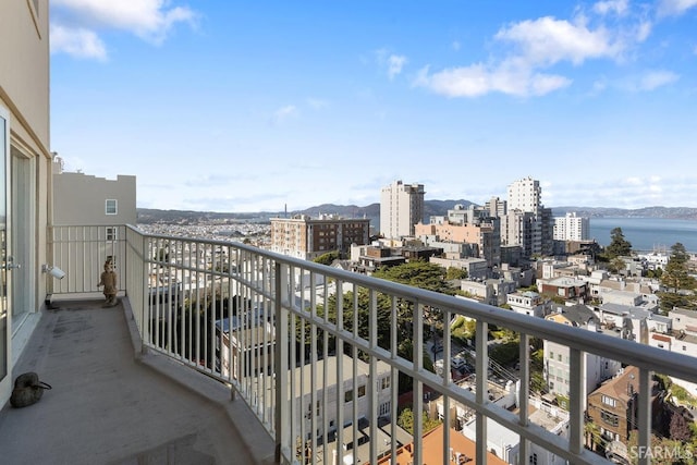 balcony with a water view and a view of city