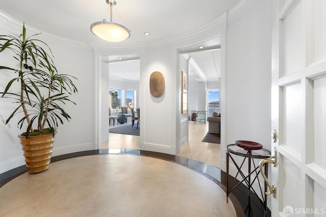 hallway with light wood-type flooring, a healthy amount of sunlight, and crown molding