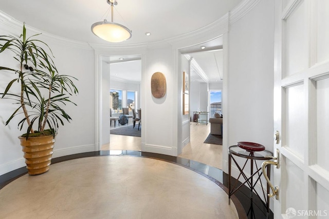 foyer entrance with a wealth of natural light, recessed lighting, baseboards, and ornamental molding