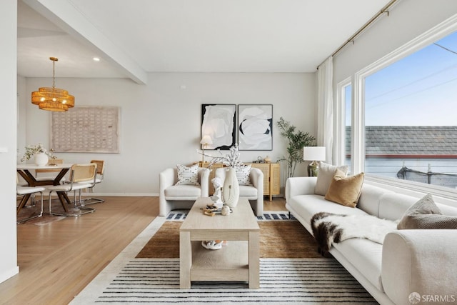 living area with recessed lighting, baseboards, wood finished floors, and beam ceiling