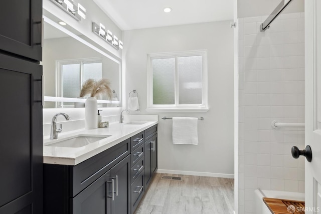 full bath featuring visible vents, a sink, wood finished floors, and double vanity