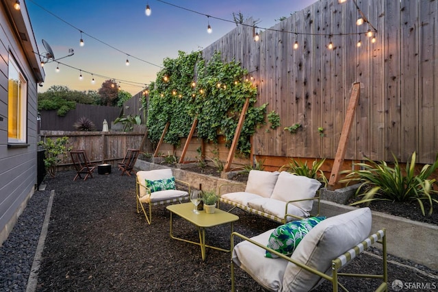 patio terrace at dusk featuring fence and outdoor lounge area