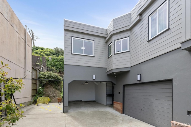 view of front of property with an attached garage, fence, and stucco siding