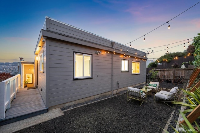 back of house with fence and a wooden deck