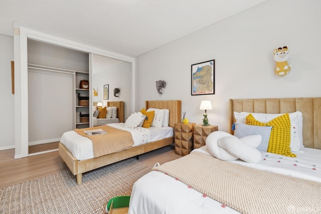 bedroom featuring a closet, baseboards, and wood finished floors