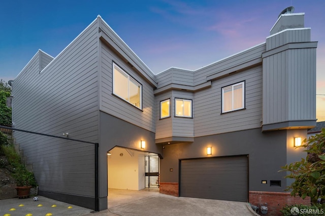 contemporary house featuring an attached garage, driveway, and stucco siding