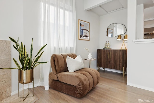 living area featuring baseboards and wood finished floors