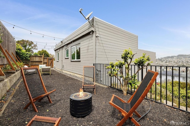 view of side of home featuring a fire pit and fence