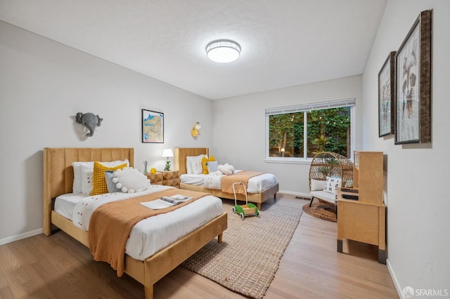 bedroom with light wood-style floors, baseboards, and visible vents