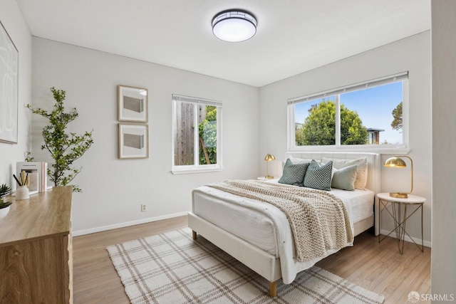 bedroom featuring baseboards and light wood-style flooring