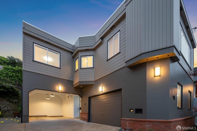 contemporary house featuring an attached garage, stucco siding, and driveway