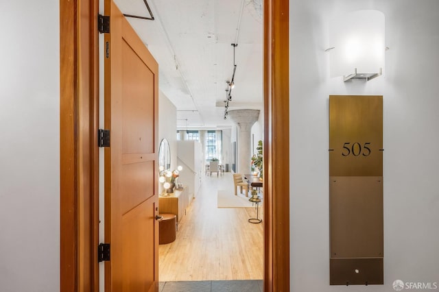 corridor featuring hardwood / wood-style floors and track lighting