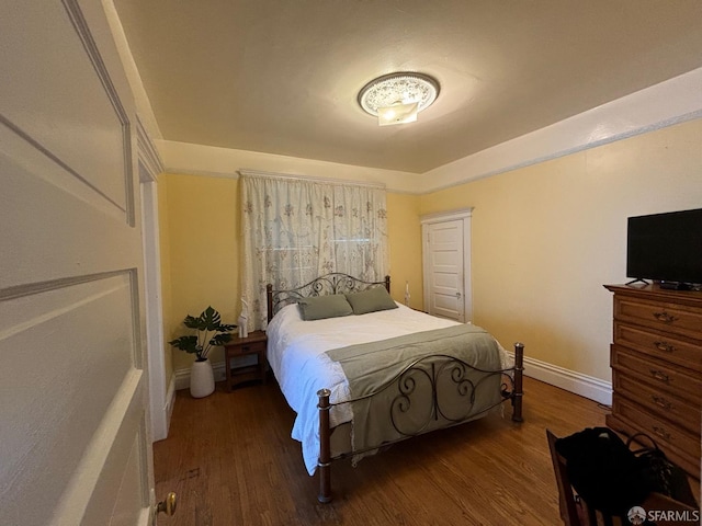 bedroom with baseboards and wood finished floors