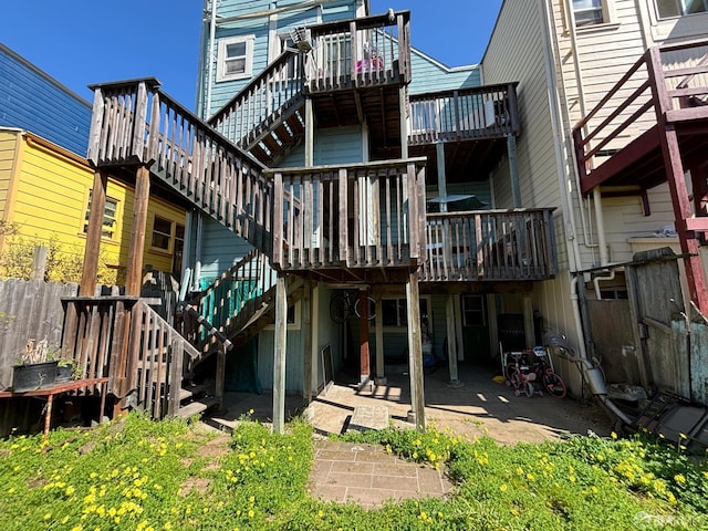 rear view of house featuring a patio area, stairs, and a deck