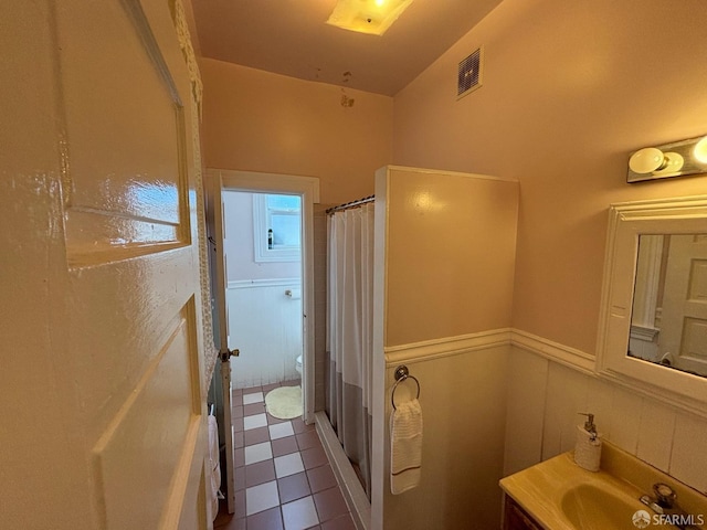 bathroom with visible vents, a shower with curtain, vanity, and toilet