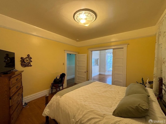 bedroom featuring baseboards and dark wood-style flooring