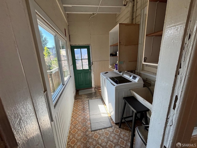 laundry area with laundry area, independent washer and dryer, and a wainscoted wall