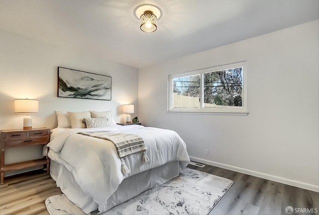 bedroom featuring baseboards and wood finished floors