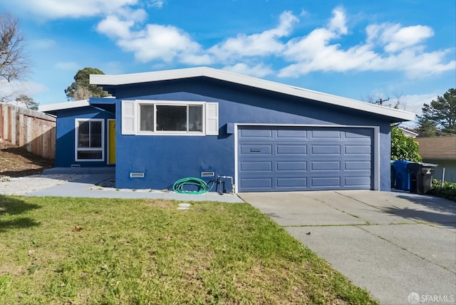 view of front of home featuring an attached garage, fence, driveway, stucco siding, and a front lawn