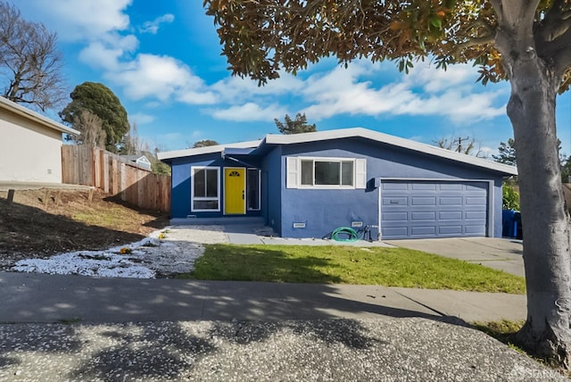 view of front of house with a garage, fence, driveway, and stucco siding