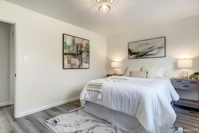 bedroom with wood finished floors and baseboards