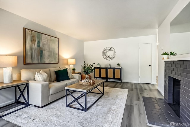 living room with a fireplace, wood finished floors, and baseboards