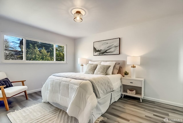 bedroom with baseboards and wood finished floors