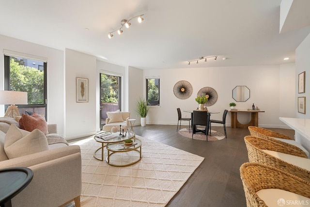 living room with a healthy amount of sunlight, baseboards, and dark wood-style flooring