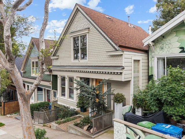 view of front of home featuring a shingled roof and fence