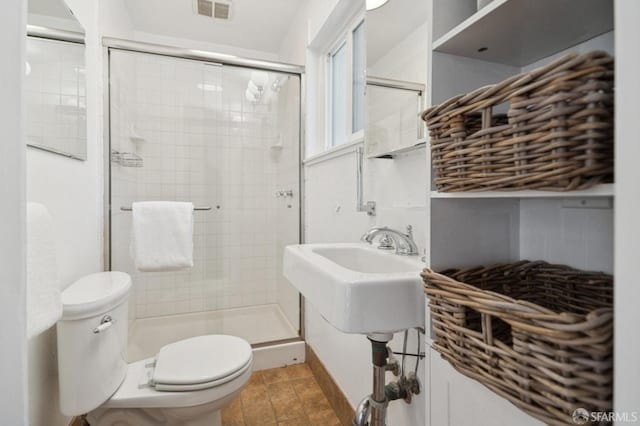 bathroom featuring visible vents, toilet, and a shower stall