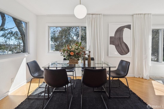 dining space featuring wood finished floors and baseboards