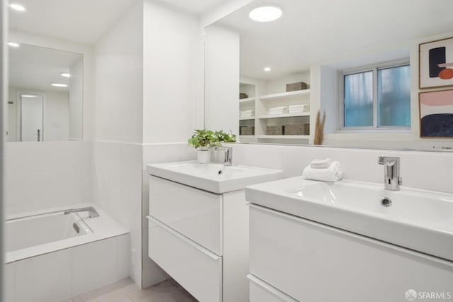 full bathroom with two vanities, recessed lighting, a sink, tile patterned flooring, and a garden tub