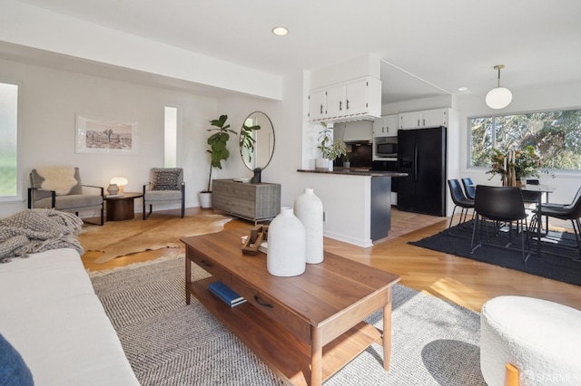 living area with light wood-style flooring and recessed lighting