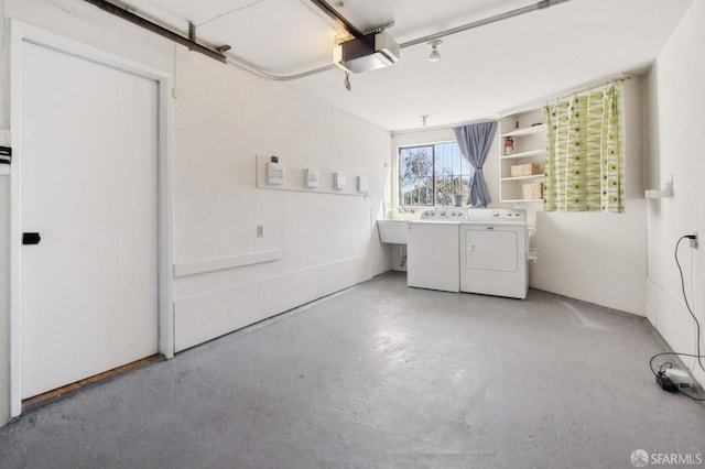 washroom featuring washer and dryer, a garage, and a sink