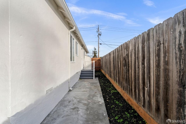 view of side of property with fence private yard, crawl space, and stucco siding