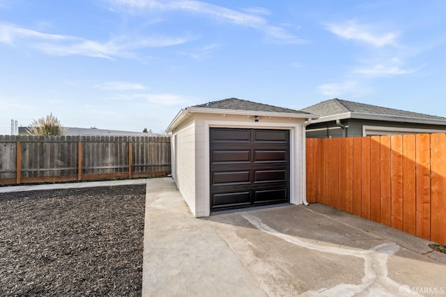 detached garage with driveway and fence