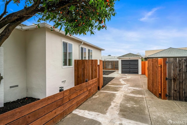 view of side of property with driveway, an outbuilding, crawl space, fence, and stucco siding